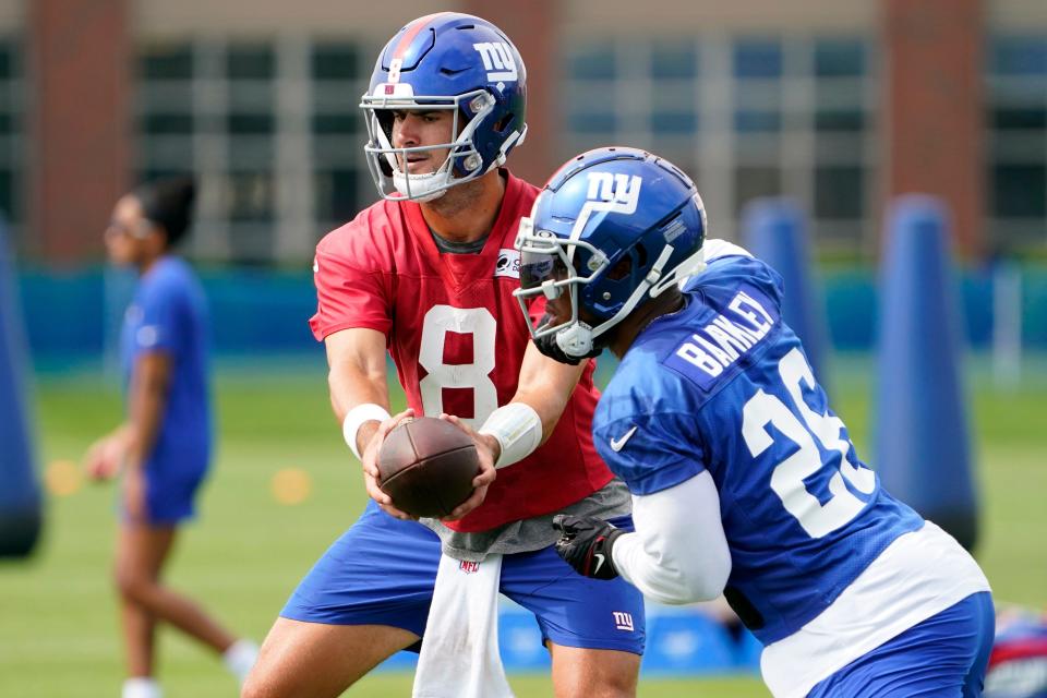 New York Giants quarterback Daniel Jones (8) hands the ball to running back Saquon Barkley (26) during the second day of training camp at the Quest Diagnostics Training Center in East Rutherford on Thursday, July 28, 2022.