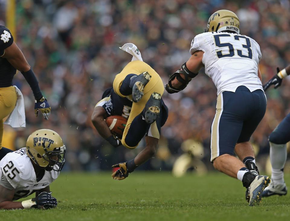 Theo Riddick #6 of the Notre Dame Fighting Irish flips in the air between Jason Hendricks #25 and Joe Trebitz #53 of the Pittsburgh Panthers at Notre Dame Stadium on November 3, 2012 in South Bend, Indiana. (Photo by Jonathan Daniel/Getty Images)