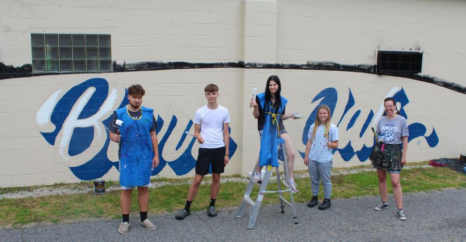 Burr Oak students Aiden Calvert, Grant Brooks, Hannah Greene and Lilly Holton with their teacher and muralist, Heidi Wolfe.