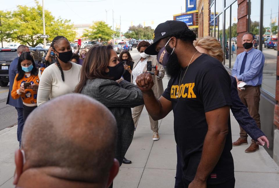 U.S. Senator and Democratic Vice Presidential nominee Kamala Harris talks with Bedrock Apparel owner Jason Trice in front of a store window in downtown Flint on September 22, 2020, as she speaks with small business owners during a campaign stop in Michigan.