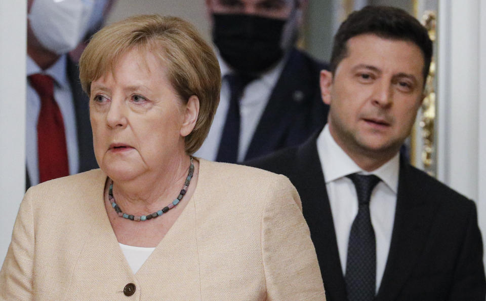 Ukrainian President Volodymyr Zelenskyy, right, and German Chancellor Angela Merkel enter a hall for a joint news conference following their talks at the Mariinsky palace in Kyiv, Ukraine, Sunday, Aug. 22, 2021. German Chancellor Angela Merkel arrived to Kyiv for a working visit to meet with top Ukrainian officials. (Sergey Dolzhenko/Pool Photo via AP)