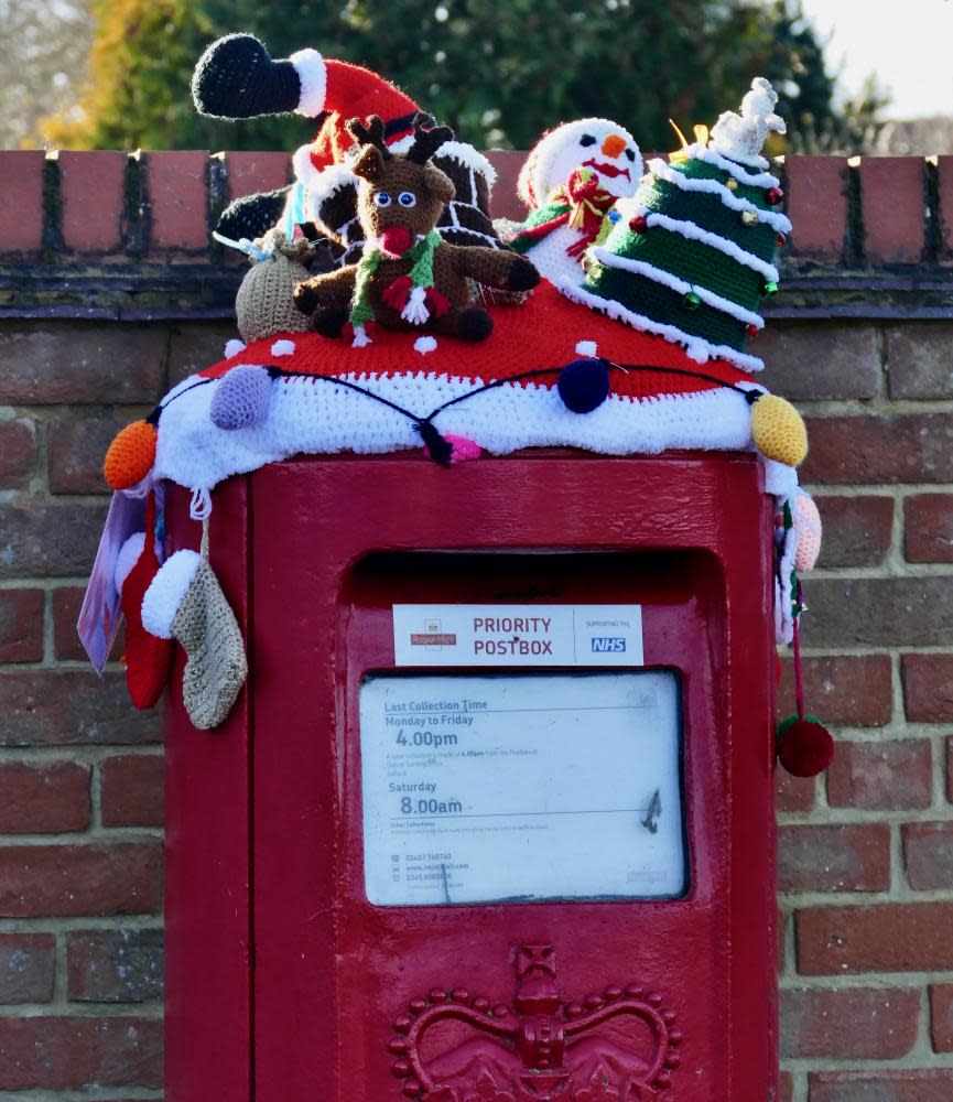 Festive knitted items on a postbox in 2021