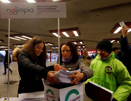 Timea Szabo(C), co-chair of opposition party Parbeszed Magyarorszagert hands over documents with signatures supporting a referendum on Budapest's 2024 Olympic bid to political movement Momentum at a stand in Budapest, Hungary, February 16, 2017.Picture taken February 16, 2017. REUTERS/Laszlo Balogh