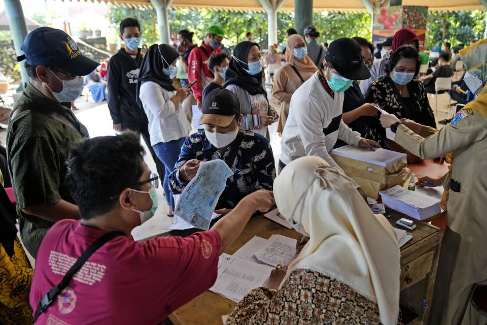 People register to receive the COVID-19 vaccine during a mass vaccination in Jakarta, Indonesia, Monday, June 21, 2021. Indonesia's president ordered authorities to speed up the country's vaccination campaign as the World Health Organization warned of the need to increase social restrictions in the country amid a fresh surge of coronavirus infections caused by worrisome variants. (AP Photo/Dita Alangkara)