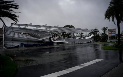 The crumbled canopy of a gas station damaged by Hurricane Irma is seen in Bonita Springs in Florida - Credit: Reuters