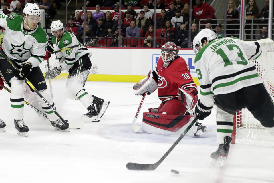 Carolina Hurricanes' Alex Nedeljkovic (39) defends the net against Dallas Stars' Jamie Oleksiak (2) and Mattias Janmark (13) during the first period of an NHL hockey game in Raleigh, N.C., on Tuesday, Feb. 25, 2020. (AP Photo/Chris Seward)