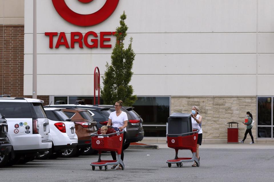 Shoppers take purchases to their vehicle in the parking lot of a Target store, Tuesday, Aug. 4, 2020, in Marlborough, Mass. (AP Photo/Bill Sikes)