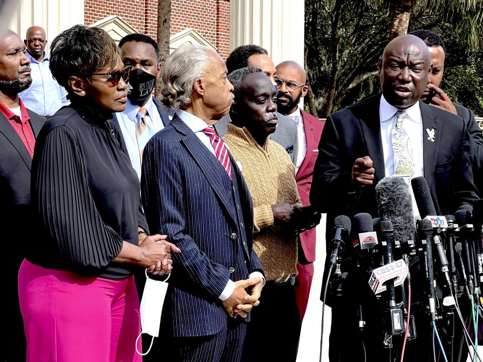 Family attorney Benjamin Crump, right, speaks as Marcus Arbery, second from right, his former wife Wanda Cooper, left, and the Rev. Al Sharpton listen outside the Glynn County courthouse, Wednesday, Nov. 10, 2021, in Brunswick, Ga. Rev. Sharpton led a prayer and spoke out against injustice during the noon break in the trial of three men charged with murder in Ahmaud Abery's shooting death. (AP Photo/Lewis M. Levine Coastal