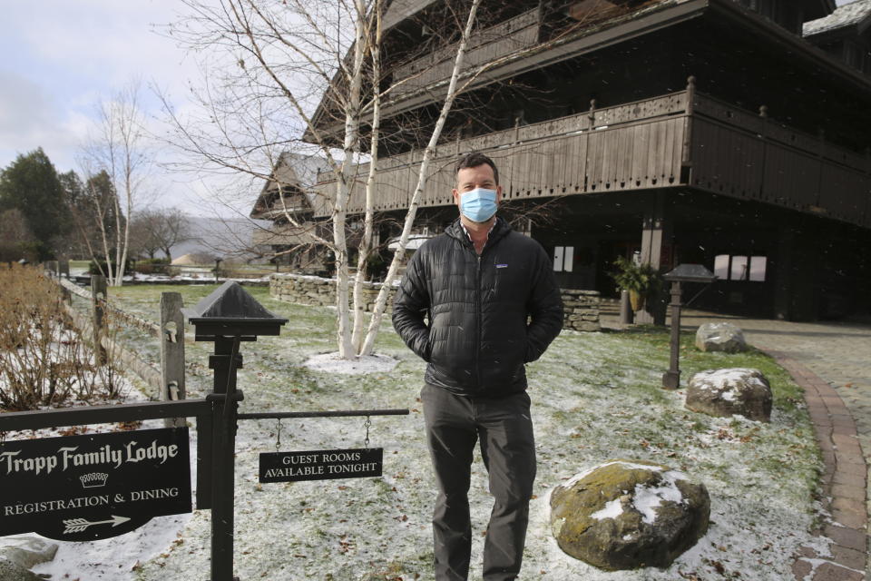 Bob Schwartz, the director of marketing of the Trapp Family Lodge poses outside the lodge on Tuesday, Dec. 15, 2020 in Stowe, Vt. Quarantine rules imposed in an attempt to stop the spread of novel coronavirus are affecting business during the normally busy holiday season. He says the rules are frustrating but be understands the need for them. He's looking forward to a time when the pandemic is over. (AP Photo/Wilson Ring)