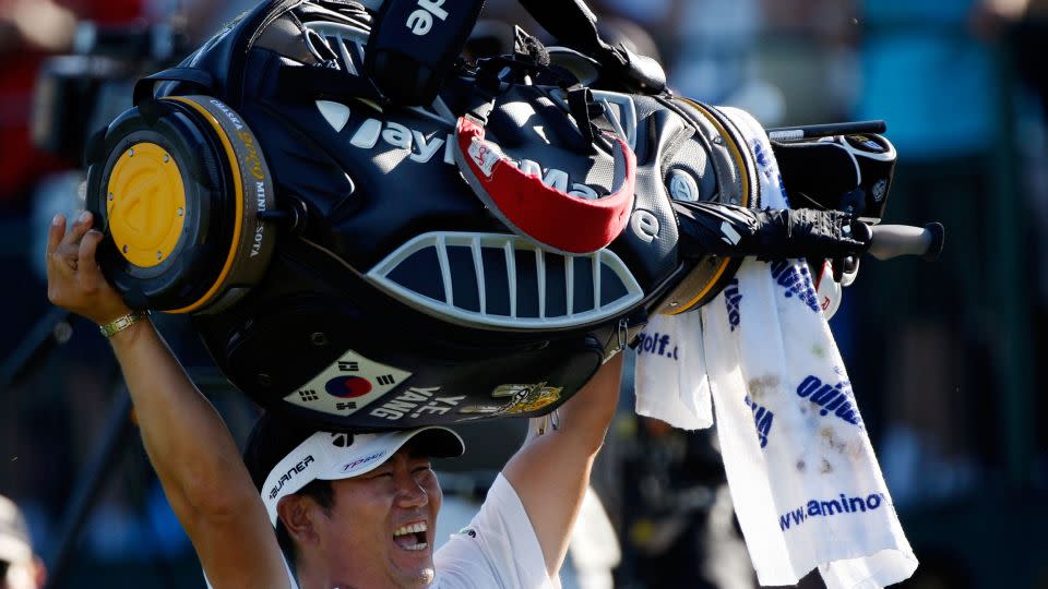 Yang triumphantly lofts his golf bag above his head. - Streeter Lecka/Getty Images