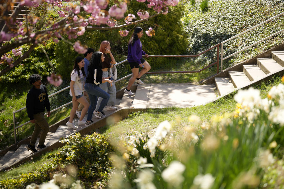 Upper Darby High School students Tanveer Kaur, from right, Joey Ngo, Fatima Afrani, Rayan Hansali, Elise Olmstead and Ata Ollah walk through the campus courtyard, Wednesday, April 12, 2023, in Drexel Hill, Pa. (AP Photo/Matt Slocum)