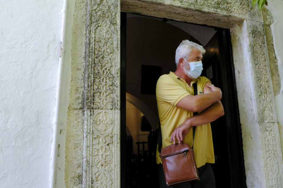 A man, who received the Johnson and Johnson COVID-19 vaccine, walks outside the church of the Virgin Mary, during a vaccination roll out, in the town of Archanes, on the island of Crete, Greece, Monday, Sept. 6, 2021. Greece has begun administering vaccinations for COVID-19 outside churches. It's a pilot program that was recently announced by the government as a means of encouraging more people to get the shots. Mobile National Health Organization units began administering shots Monday in a church yard in the town of Archanes near the city of Heraklion on the southern island of Crete. (AP Photo/Michael Varaklas)