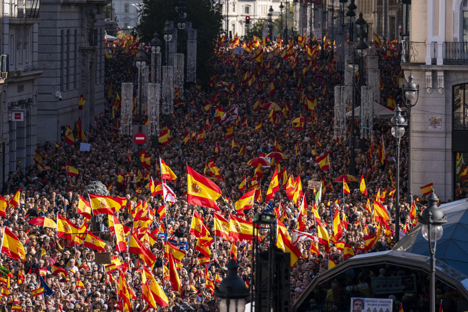 Crowds with Spanish flags pack the central Puerta del Sol during a protest called by Spain's Conservative Popular Party in Madrid, Spain, Sunday Nov.12, 2023. The Popular Party are protesting Spain's Socialists deal to grant amnesty to Catalan separatists in exchange for support of new government. (AP Photo/Joan Mateu Parra)