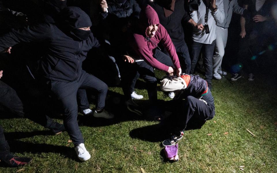 A pro-Palestinian demonstrator is beaten by counter protesters on the campus of the University of California Los Angeles in the early hours of Wednesday.