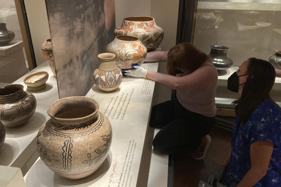 Finishing touches are made on a community-curated exhibition of Native American pottery from the Pueblo Indian region of the U.S. Southwest at the Museum of Indian Art and Culture, on July 28, 2022, in Santa Fe, N.M. Native American artists, political leaders and storytellers picked their favorite ceramic pieces from institutional collections that didn't always defer to Indigenous perspectives. Showings also are scheduled at the Metropolitan Museum of Art in New York and museums in Houston and St. Louis. (AP Photo/Morgan Lee)