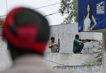 Indian policemen take their positions next to a police station during a gunfight at Dinanagar town in Gurdaspur district of Punjab, India, July 27, 2015. REUTERS/Munish Sharma