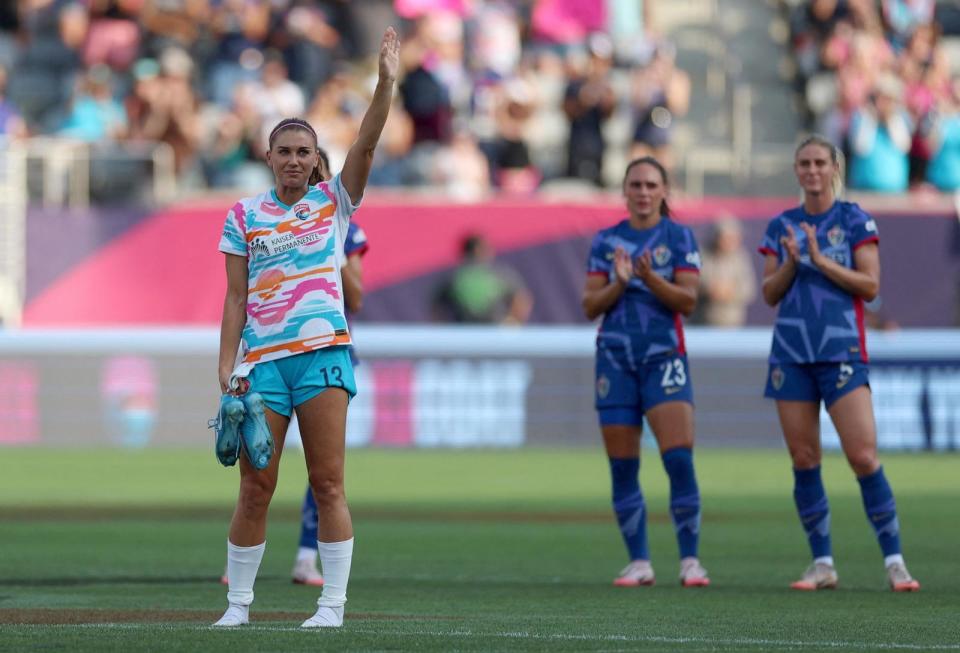 PHOTO: San Diego Wave FC forward Alex Morgan holds her soccer cleats as she waves to fans after being substituted in the final game of her career in San Diego on Sept. 8, 2024 (Abe Arredondo/USA TODAY Sports via Reuters)