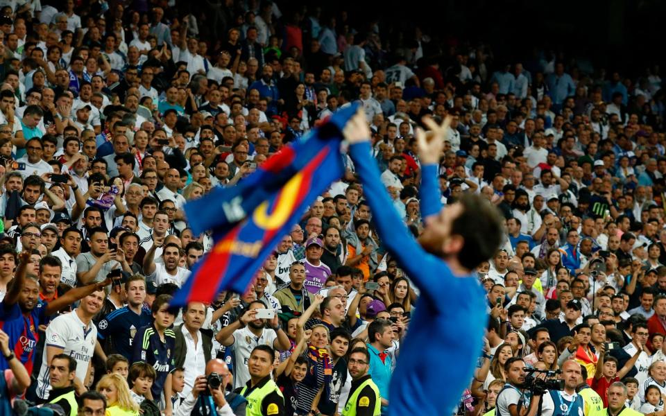 Lionel Messi holds up his shirt to the travelling Barcelona fans - AFP