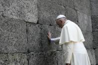 Pope Francis touches the "Wall of Death", a firing squad execution spot in the Nazi death camp Auschwitz, on July 29, 2016