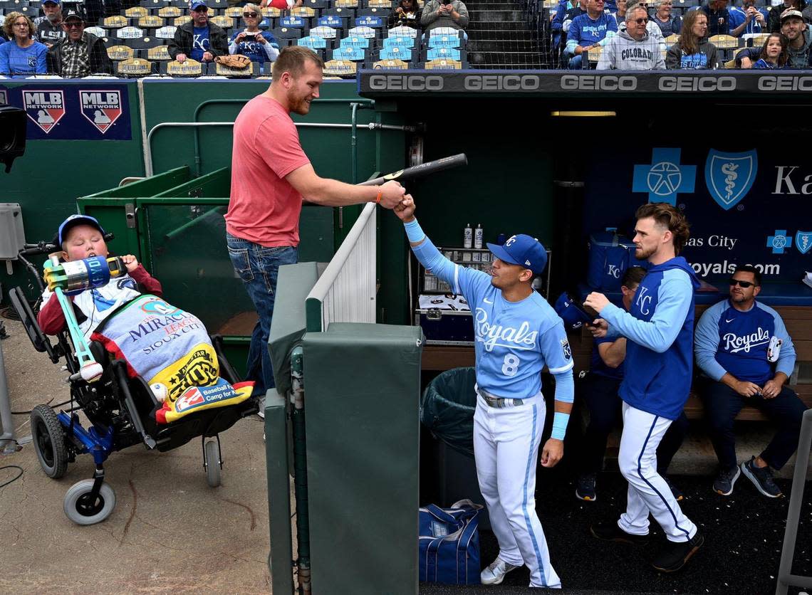 Kayden Rhoades was given 24 hours to live at birth, but 15 years later he threw out the first pitch on Thursday at Kauffman Stadium with the loving help of his family. Rhoades, who was born with hydranencephaly, used a device his father Dustin, above, created for him to complete the feat. Kayden also received a bat from Royals’ second baseman, Nicky Lopez, right. It was a bucket list day in every way for the family from Sioux City, Iowa.