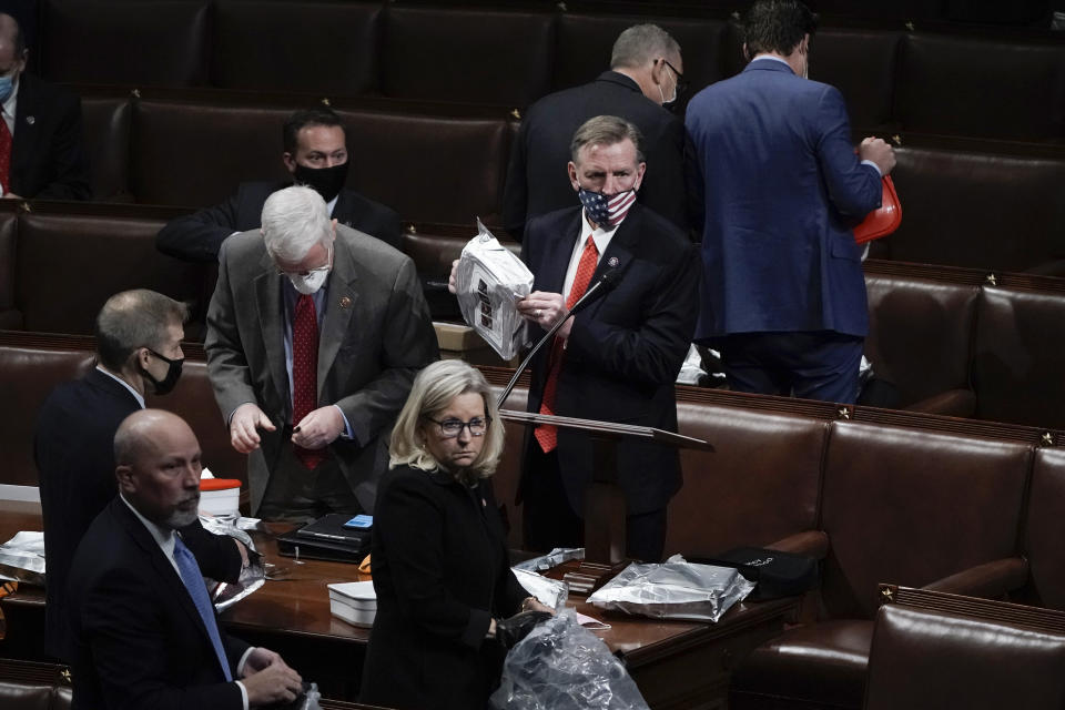 FILE - Rep. Paul Gosar, R-Ariz., center, and other lawmakers prepare to evacuate the floor as rioters try to break into the House Chamber at the U.S. Capitol on Wednesday, Jan. 6, 2021, in Washington. (AP Photo/J. Scott Applewhite, File)