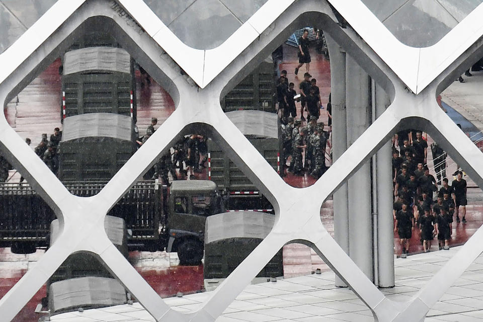 This Friday, Aug. 16, 2019, photo shows members of China's paramilitary People's Armed Police, in military fatigues and t-shirts, are seen at Shenzhen Bay Stadium in Shenzhen, China. Chinese police marched and practiced crowd control tactics at the sports complex in Shenzhen across from Hong Kong on Friday, in what some interpreted as a threat against pro-democracy protesters in the semiautonomous territory.(Madoka Ikegami/Kyodo News via AP)