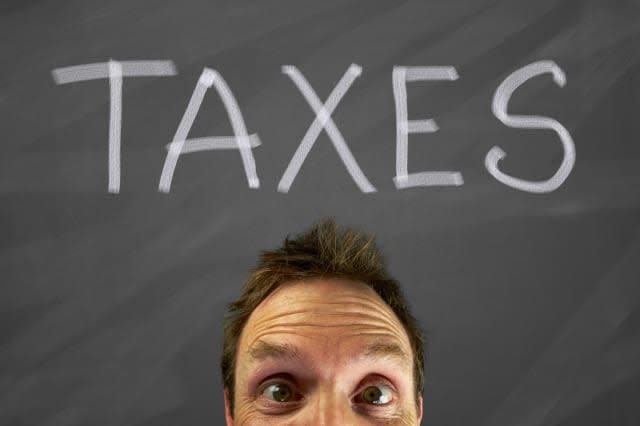 Mans head with a taxes message on a blackboard