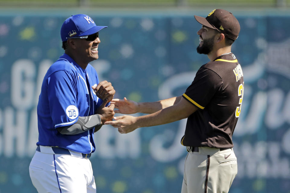 Former Kansas City Royals royals teammates Royals' Salvador Perez, left, and San Diego Padres' Eric Hosmer talk before a spring training baseball game Monday, Feb. 24, 2020, in Surprise, Ariz. (AP Photo/Charlie Riedel)