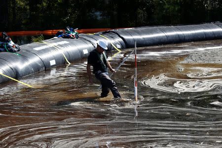 Santee Cooper worker Carl McCrea checks the water levels around a 6000 foot long Aqua Dam built to keep sediment from a coal ash retention pond from going into the flooded Waccamaw River in the aftermath of Hurricane Florence in Conway, South Carolina, U.S. September 26, 2018. REUTERS/Randall Hill