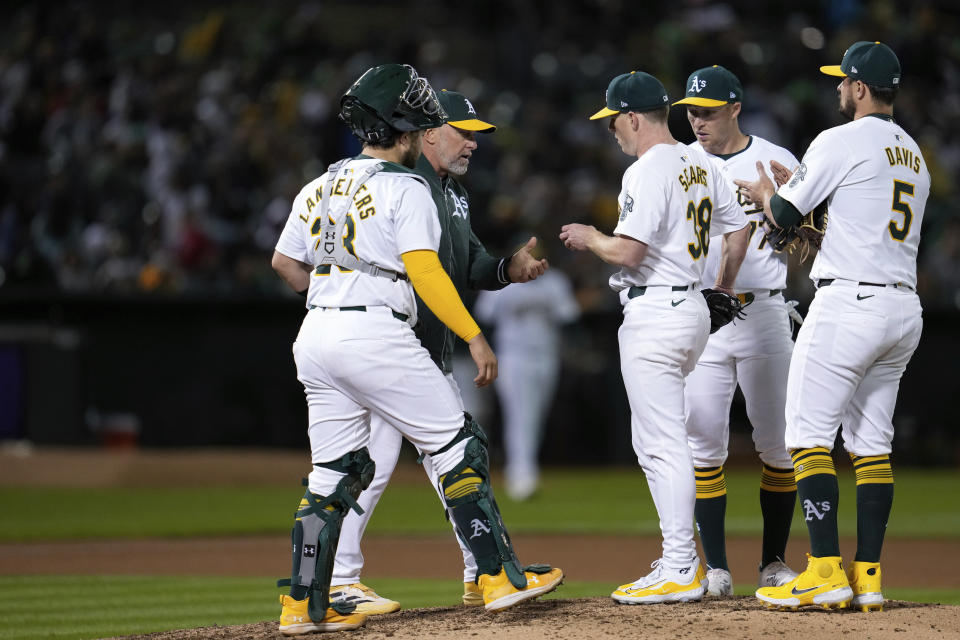 Oakland Athletics pitcher JP Sears (38) hands the ball over to manager Mark Kotsay, second from left, as he exits during the seventh inning of a baseball game against the Miami Marlins, Friday, May 3, 2024, in Oakland, Calif. (AP Photo/Godofredo A. Vásquez)