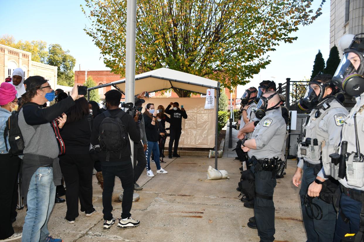 Protesters and law enforcement officers stand opposite each other during a rally on Oct. 31 in Graham. The rally turned violent when law enforcement officers pepper-sprayed some demonstrators and arrested others.