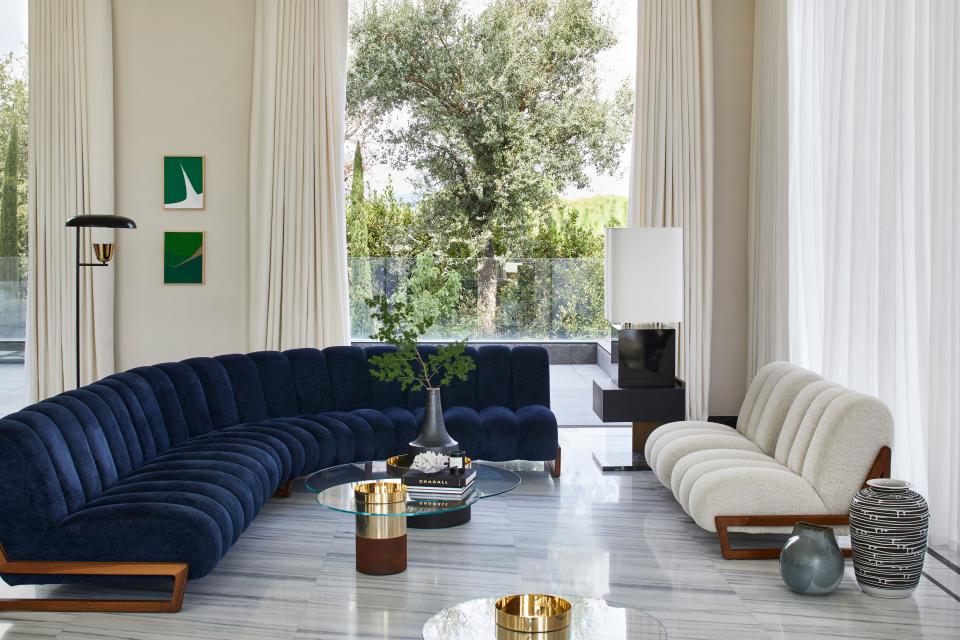 In the living room is a Grand Theodore sofa and armchairs custom designed by the duo. Coffee table by Gallotti & Radice and art by French artist Ludovic Philippon. Other objects include vintage ceramics and lamps by Michel Boyer and Parachilna. The floors are Lazza marble.