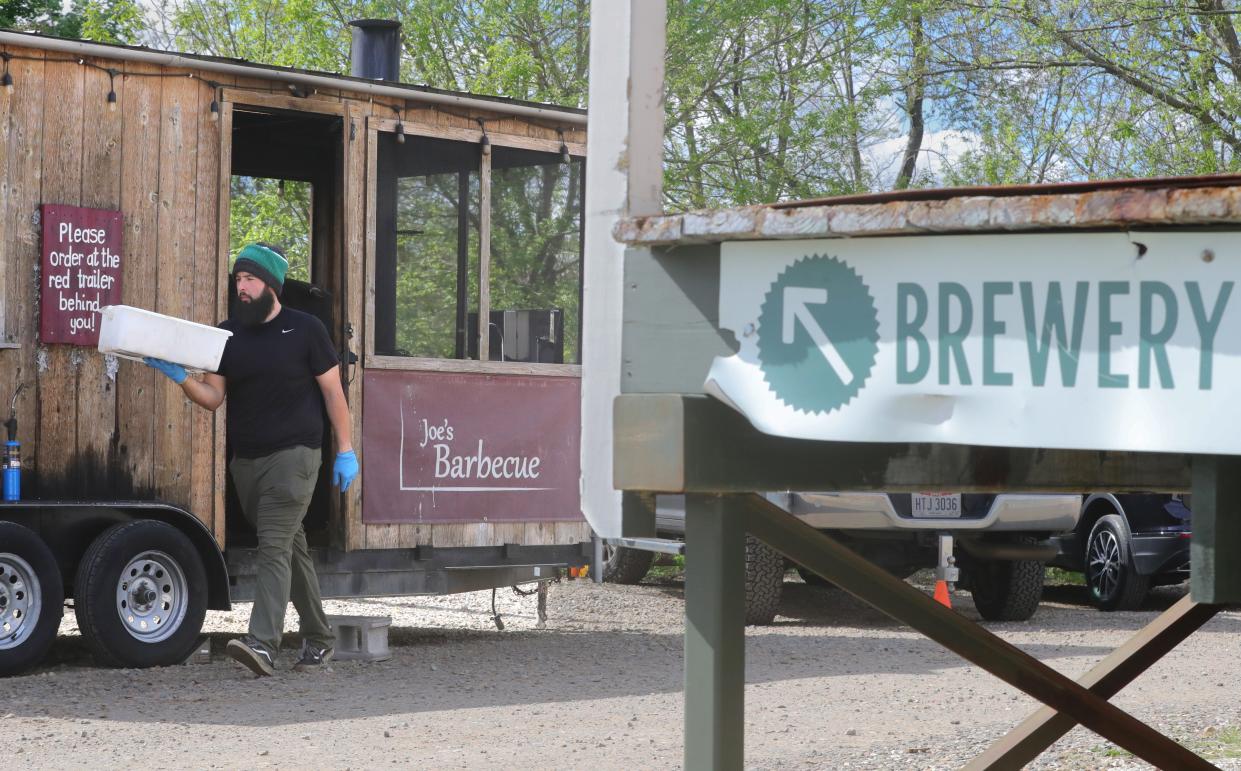 Joe Menendez, owner of Joe's Barbecue, works at his smoker parked temporarily at the North Water Brewing Company on Crain Avenue in Kent to satisfy his mobile food license requirement.