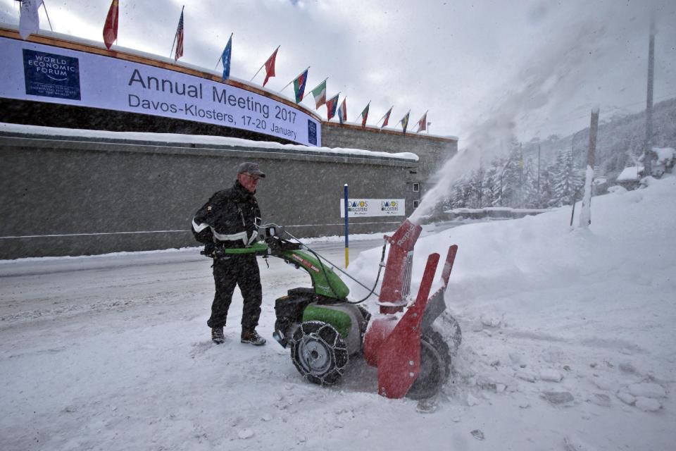 A worker uses a snow blower to clear the area in front of the congress center where the annual meeting, World Economic Forum, will take place in Davos, Switzerland, Sunday Jan. 15, 2017. Business and world leaders are gathering for the annual meeting in Davos. (AP Photo/Michel Euler)