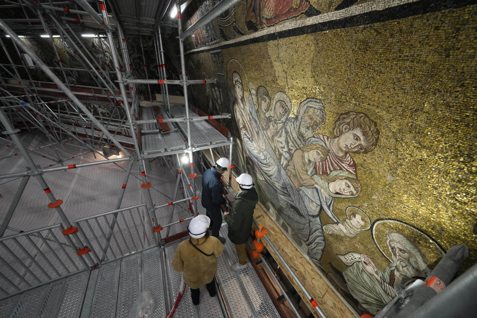 Technicians work on the restoration of the mosaics that adorn the dome of one of the oldest churches in Florence, St. John's Baptistery, in Florence, central Italy, Tuesday Feb. 7, 2023. The restoration work will be done from an innovative scaffolding shaped like a giant mushroom that will stand for the next six years in the center of the church, and that will be open to visitors allowing them for the first and perhaps only time, to come come face to face with more than 1,000 square meters of precious mosaics covering the dome. (AP Photo/Andrew Medichini)