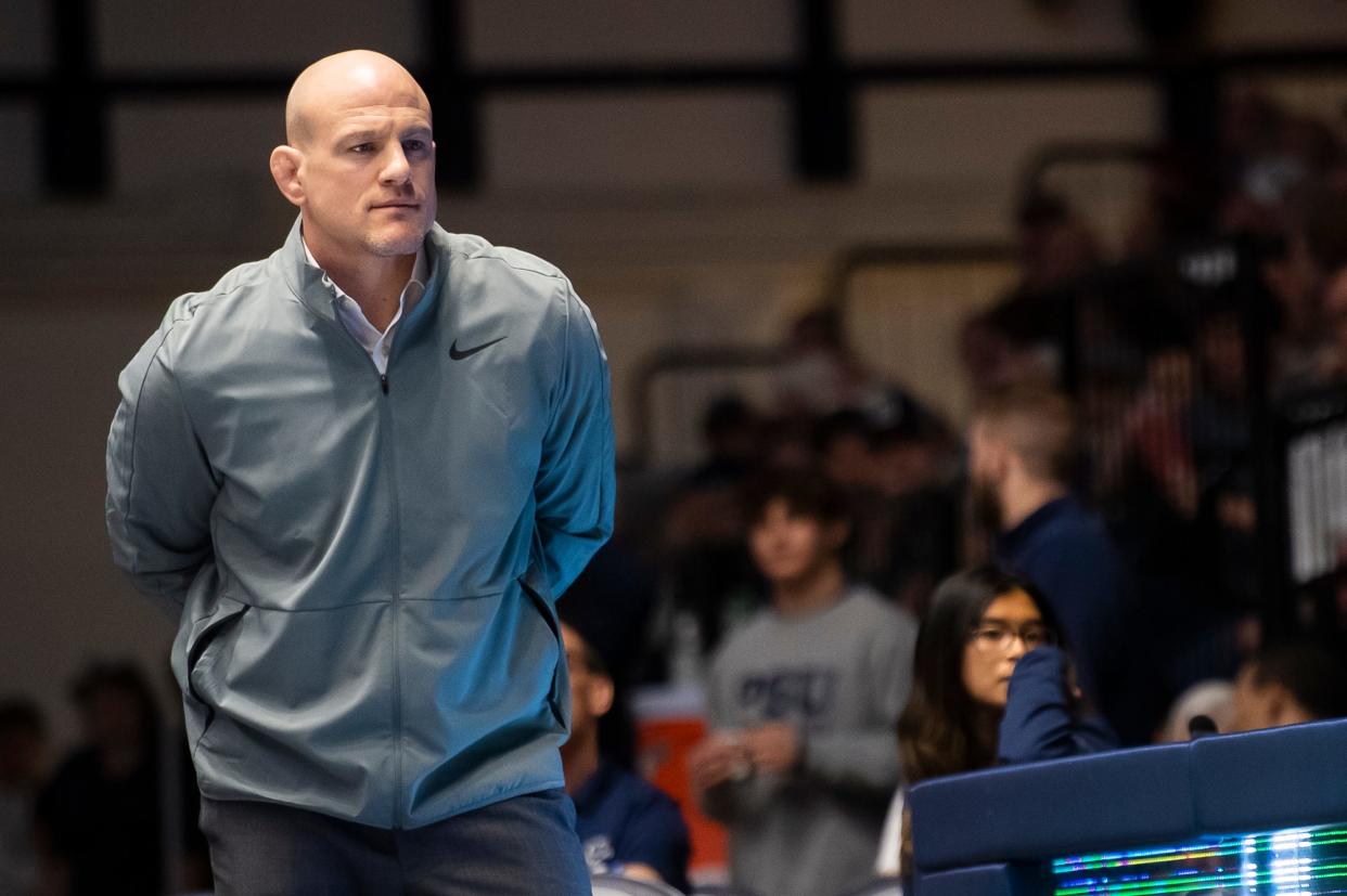 Penn State head wrestling coach Cael Sanderson looks on during a mat-side video review during a dual meet against Ohio State on Feb. 2, 2024, in State College, Pa. The Nittany Lions won, 28-9.