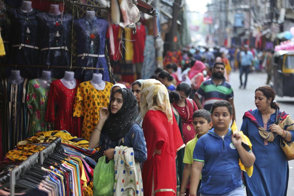 People shop at a market on the eve of Eid al Adha, in Jammu, India, Sunday, Aug.11, 2019. Authorities in Indian-administered Kashmir said that they eased restrictions Sunday in most parts of Srinagar, the main city, ahead of an Islamic festival following India's decision to strip the region of its constitutional autonomy. There was no immediate independent confirmation of reports by authorities that people were visiting shopping areas for festival purchases as all communications and the internet remain cut off for a seventh day. (AP Photo/Channi Anand)