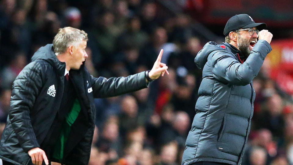 Ole Gunnar Solskjaer and Jurgen Klopp shout from the sideline during the Premier League.