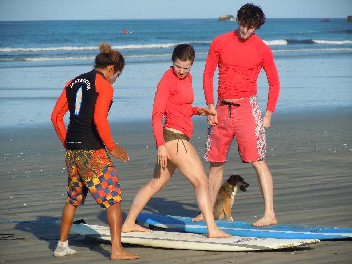 This February 2014 photo released by Kristina MacKulin shows a surfing instructor giving lessons to beginners at Playa Guiones in Nosara, Costa Rica. Nosara is a scenic coastal region with a variety of outdoor recreation activities for visitors. (AP Photo/Kristina MacKulin)