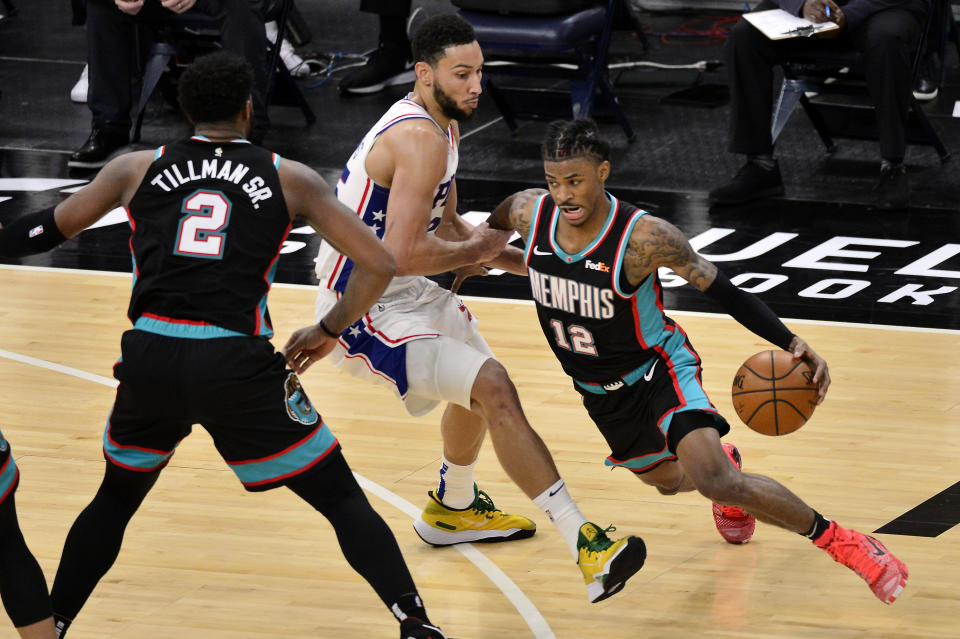 Memphis Grizzlies guard Ja Morant (12) drives around Philadelphia 76ers guard Ben Simmons during the second half of an NBA basketball game Saturday, Jan. 16, 2021, in Memphis, Tenn. (AP Photo/Brandon Dill)