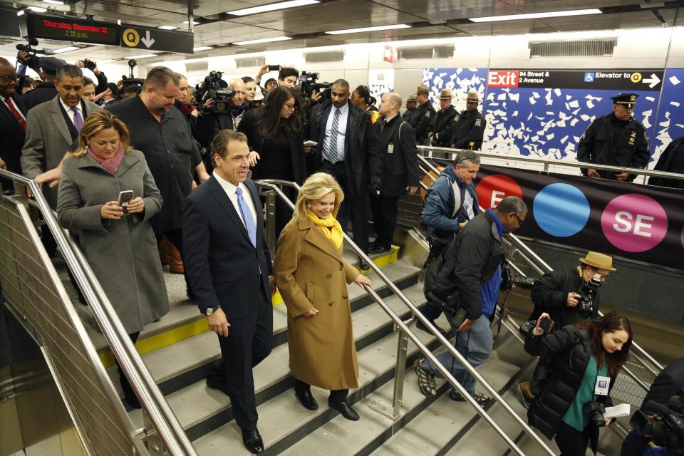 FILE- In this Dec. 22, 2106 file photo, New York Gov. Andrew Cuomo, left, is surrounded by other guests and reporters as he tours the new 86th Street subway station on the Second Avenue subway in New York. Passengers can begin riding the new line at noon on Sunday, Jan. 1, 2017. (AP Photo/Seth Wenig, File)