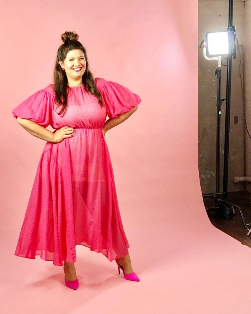 Tanya Hennessy wearing a pink dress and high heels posing for a photoshoot