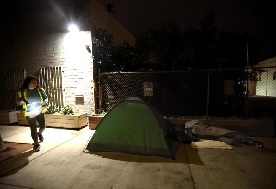 Wah Chen counts a homeless man sleeping next to his tent in Venice