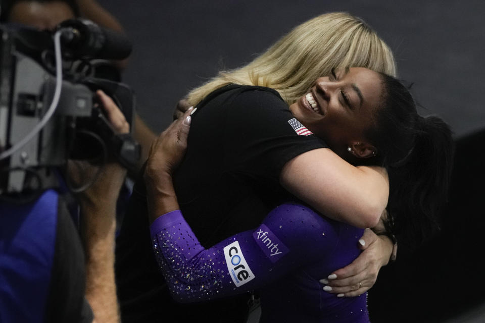 United States' Simone Biles is hugged by her coach after her beam exercise during the apparatus finals at the Artistic Gymnastics World Championships in Antwerp, Belgium, Sunday, Oct. 8, 2023. (AP Photo/Virginia Mayo)