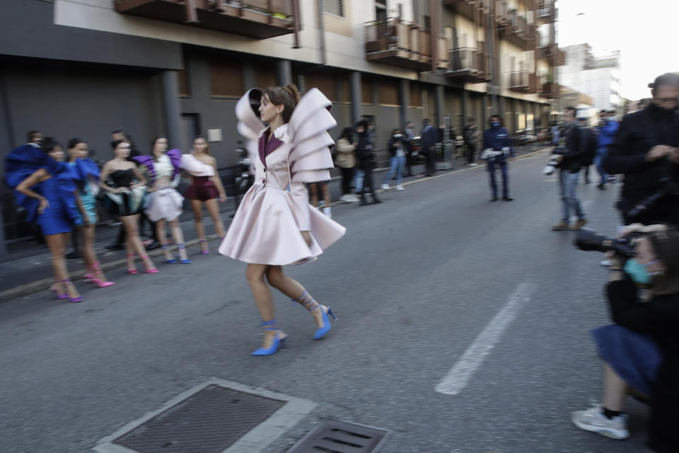 A young model shows a creation by fashion student Nora Bourelly on a street outside Valentino women's Spring-Summer 2021 fashion show location, in Milan, Italy, Sunday, Sept. 27, 2020. (AP Photo/Luca Bruno).