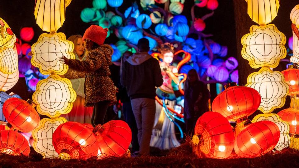 Chelsea Johnson and Christina Boyd immerse themselves in into one of the displays at the NC Chinese Lantern Festival on Tuesday, November 14, 2023 at Koka Booth Amphitheater in Cary, N.C. Robert Willett/rwillett@newsobserver.com