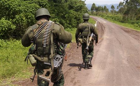 Congolese armed forces (FARDC) soldiers take position along a road as they advance while battling M23 rebels in Kibumba, north of Goma October 26, 2013. REUTERS/Kenny Katombe