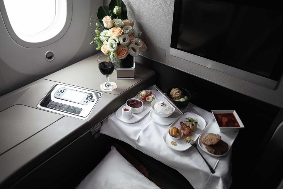 A first class seat during dinner service meal on an airplane