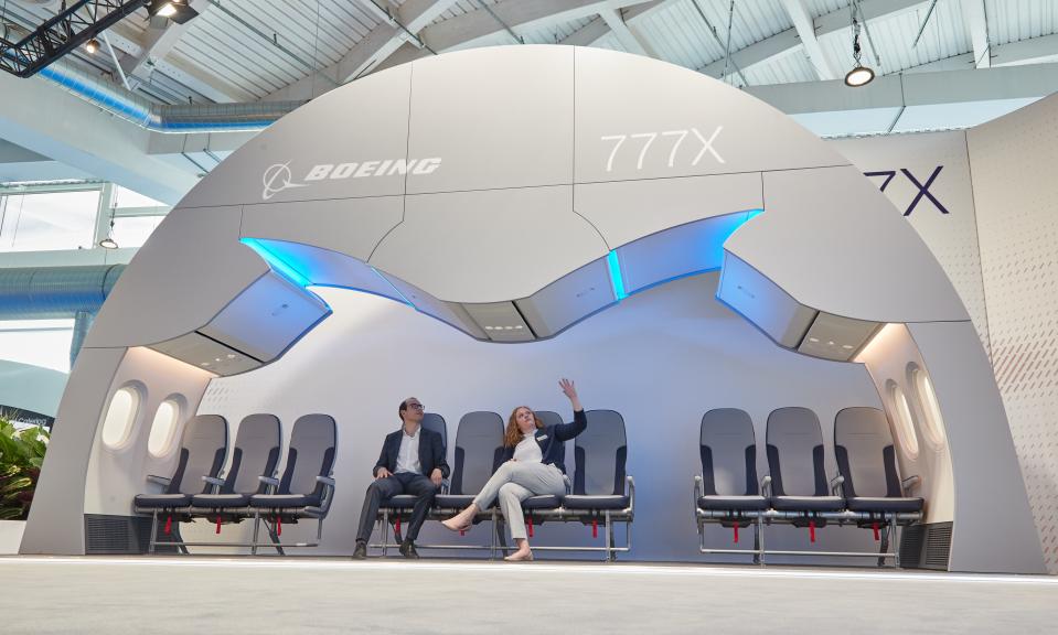 Two people sitting in 10-abreast Boeing 777X cabin mockup.