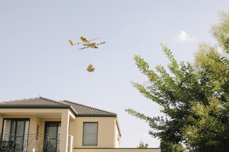 Wing drone delivering a package above a house
